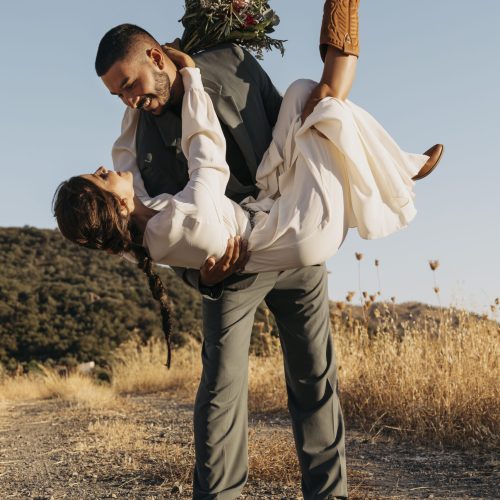 full-shot-happy-groom-holding-bride