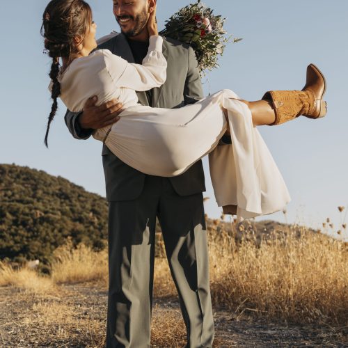 full-shot-smiley-groom-holding-bride